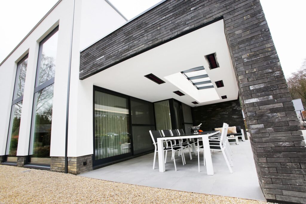 Grauer und weißer moderner Außenbereich mit schwarzem Mauerwerk, Dach und elektrischen Heizkörpern